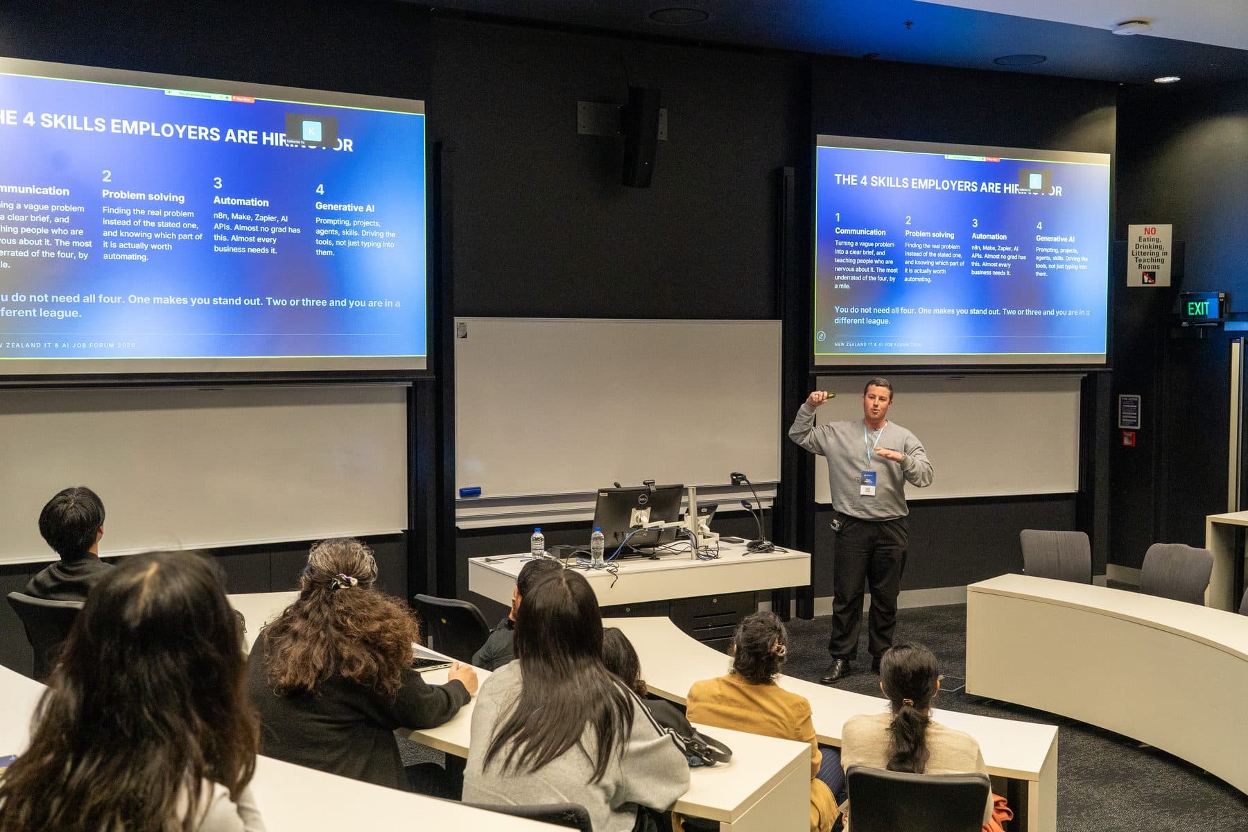 Blake Harkness presenting "The 4 skills employers are hiring for" on twin screens to students at the NZ IT and AI Job Forum
