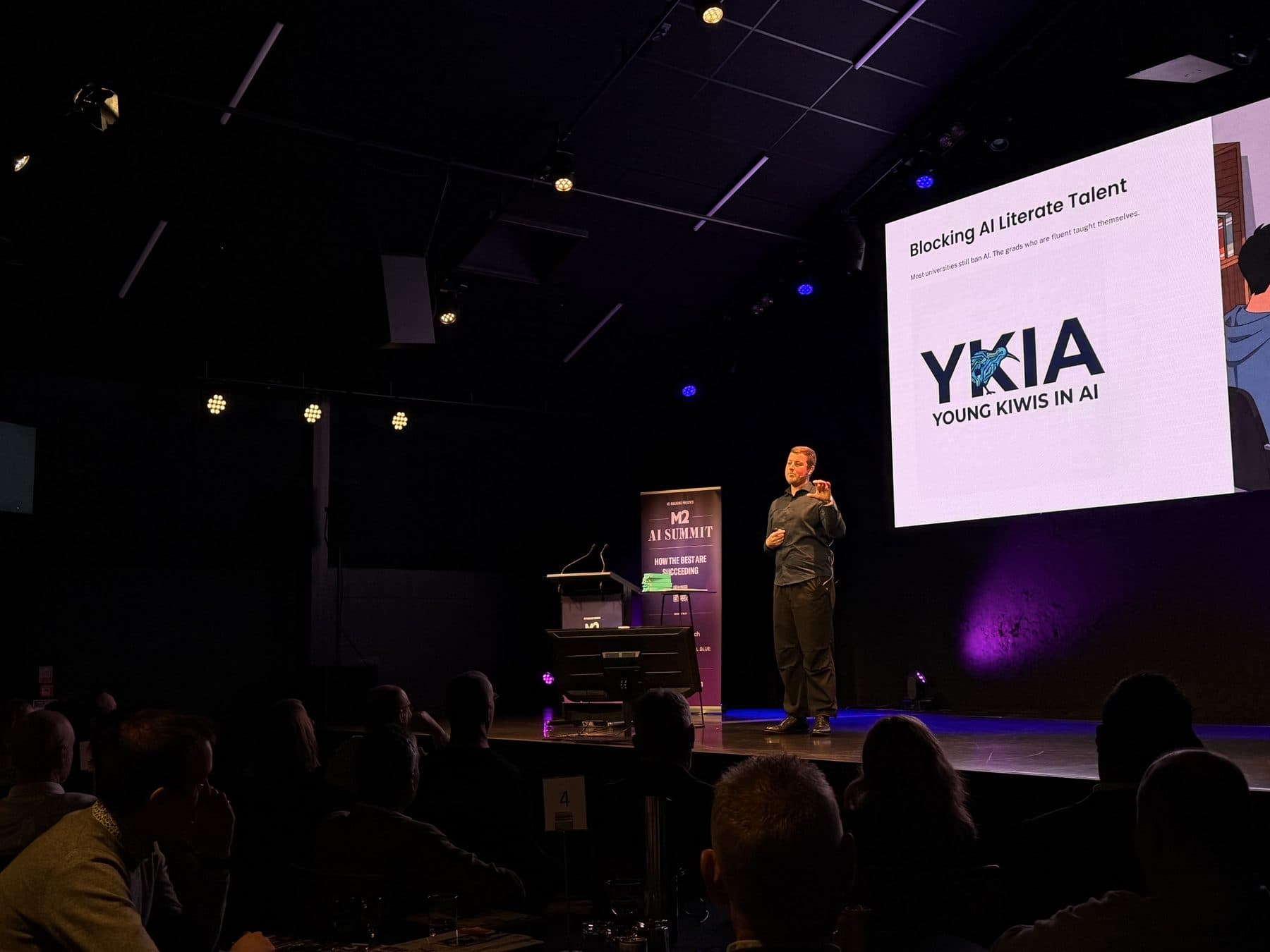 Blake Harkness presenting Young Kiwis in AI on stage at the M2 AI Summit
