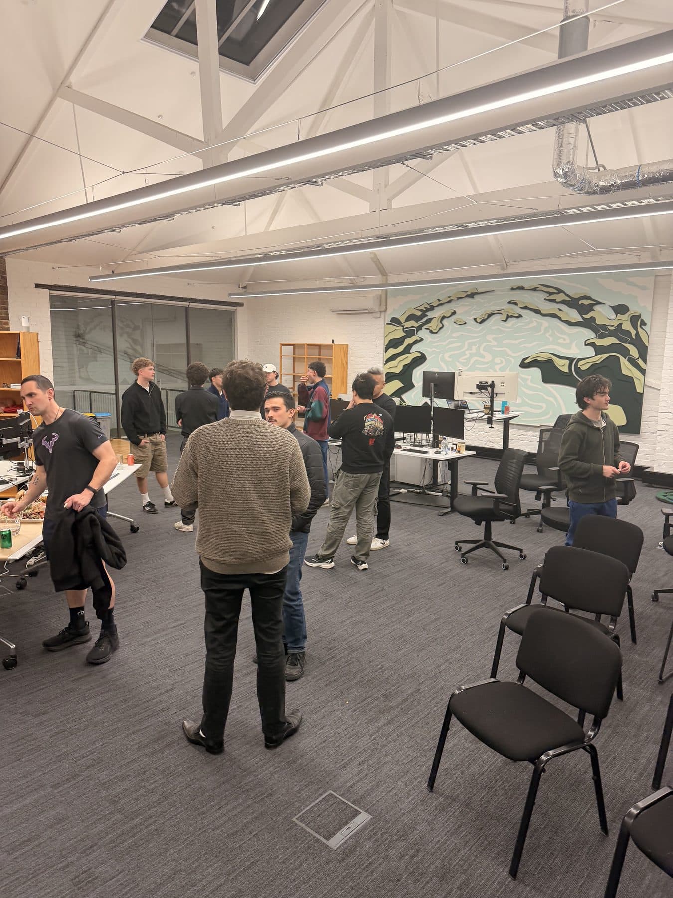 Young Kiwis in AI members talking in small groups after the talks at Flock Consulting in Dunedin