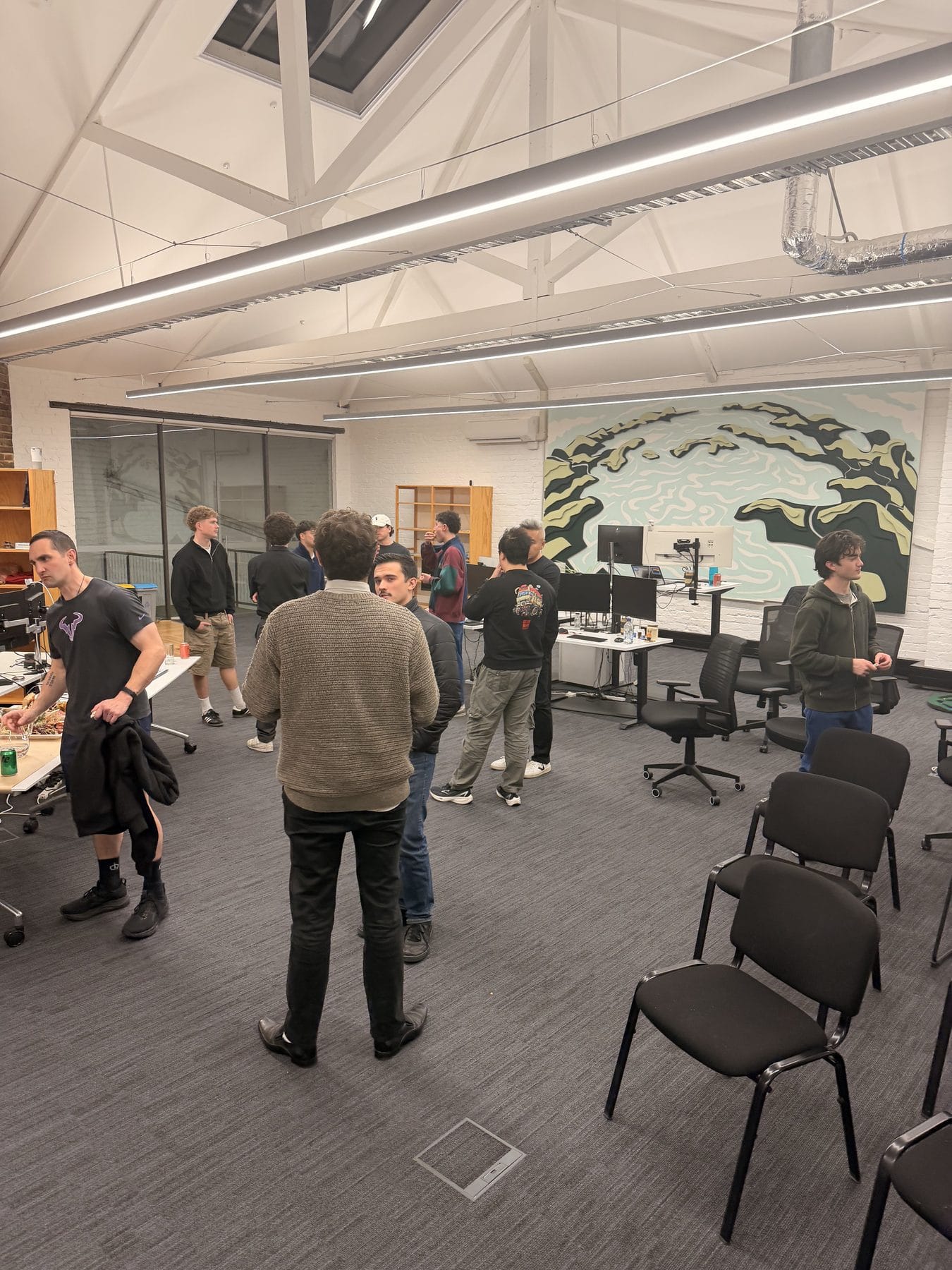 Young Kiwis in AI members talking in small groups after the talks at Flock Consulting in Dunedin