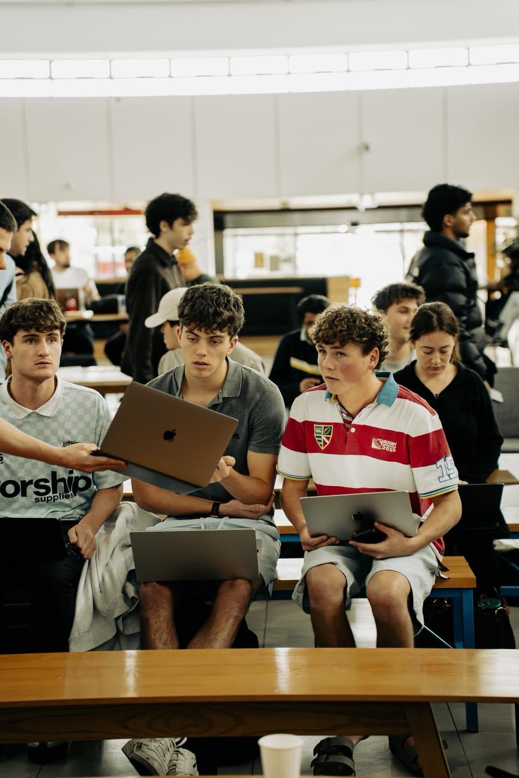 Young Kiwis in AI members sharing laptops while building their product at the SaaSathon in Christchurch